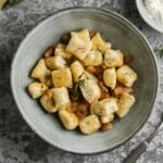 zdjęcie bezglutenowych gnocchi z dodatkami, podanych na głębokim talerzu z widelcem obok