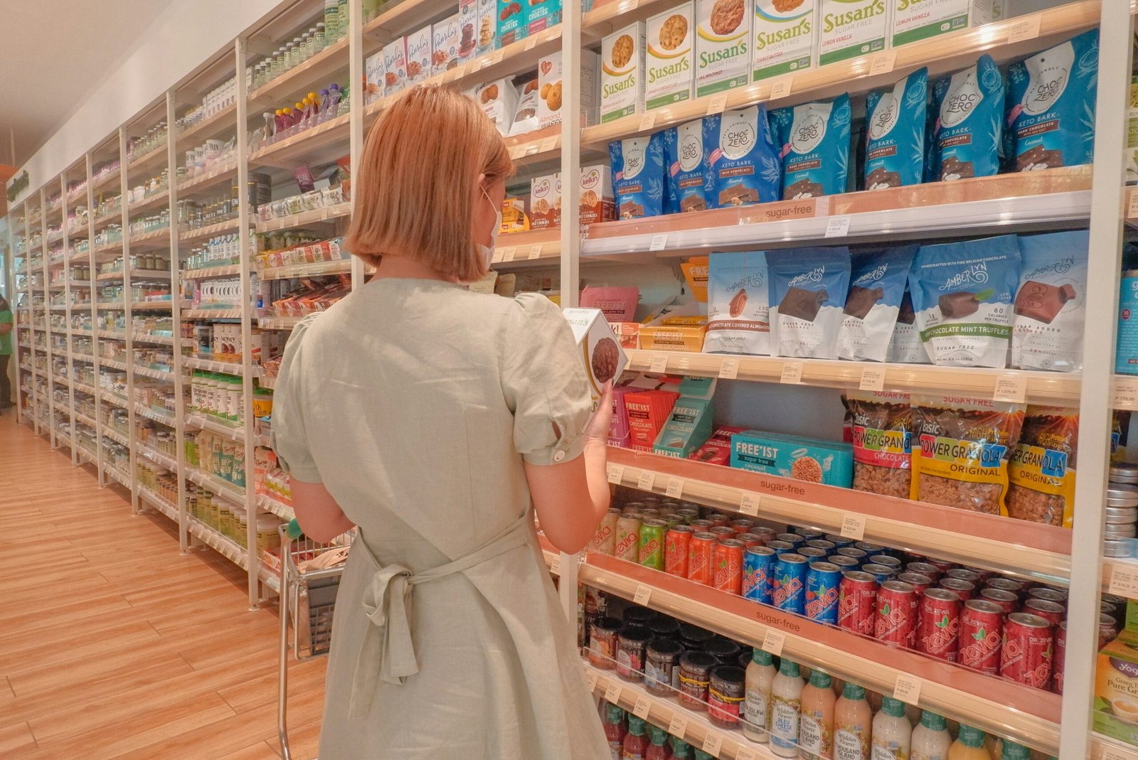 zdjęcie kobiety stojącej tyłem i czytającej etykiety w bezglutenowym dziale w supermarkecie