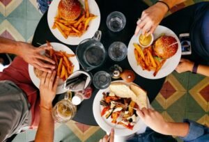 Posiłek w restauracji – burgery z frytkami na stole, przykład jedzenia poza domem w kontekście diety bezglutenowej