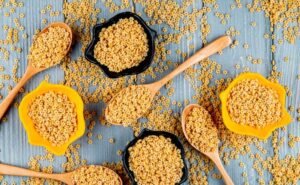 Kasza bezglutenowa w drewnianych łyżkach i miseczkach na drewnianym stole – naturalny produkt w kuchni bezglutenowej, pełen smaku i wartości odżywczych.