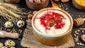 Kasza manna z owocami w misce – kasza pszenna zawierająca gluten, niewskazana na diecie bezglutenowej i przy celiakii