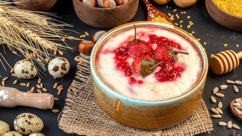 Kasza manna z owocami w misce – kasza pszenna zawierająca gluten, niewskazana na diecie bezglutenowej i przy celiakii