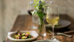 Eleganckie danie bezglutenowe z rybą i warzywami podane w restauracji, kieliszek białego wina