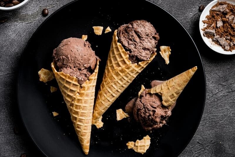 zdjęcie lodów czekoladowych w wafelkach ułożonych na talerzu na stole