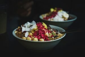 Miska śniadaniowa z granolą, kokosem, malinami liofilizowanymi i owocami, opcja bez glutenu