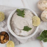 zdjęcie smalcu bez glutenu podanego w białej miseczce, z dodatkiem liści pietruszki i plasterka limonki