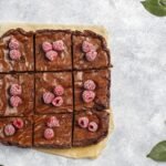 Bezglutenowy murzynek – puszyste ciasto czekoladowe pokrojone na kawałki, udekorowane malinami