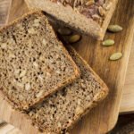 Chleb bez mąki z ziaren na drewnianej desce w domowym otoczeniu