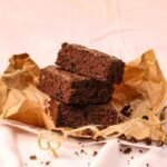 Ciasto bez mąki i cukru, czekoladowe i wilgotne, pokrojone na kawałki i ułożone na papierze, podane w naturalnym domowym stylu