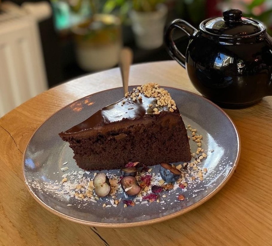 zdjęcie bezglutenowego ciasta brownie podanego na stole w kawiarni obok imbryka na herbate