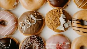 Bezglutenowe pączki i donuty z różnymi polewami i dekoracjami na Tłusty Czwartek.