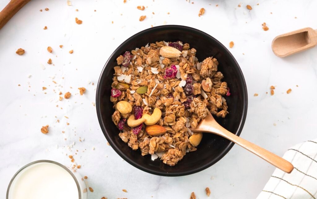 Chrupiąca granola bezglutenowa zdjęcie granoli bezglutenowej podanej w czarnej misce z dodatkiem suszonych owoców