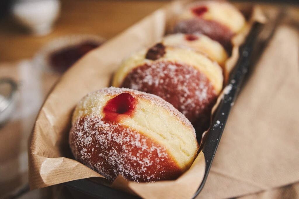 pączki bezglutenowe zdjęcie nadzianych pączków bez glutenu ułożonych w keksówce wyłożonej papierem do pieczenia