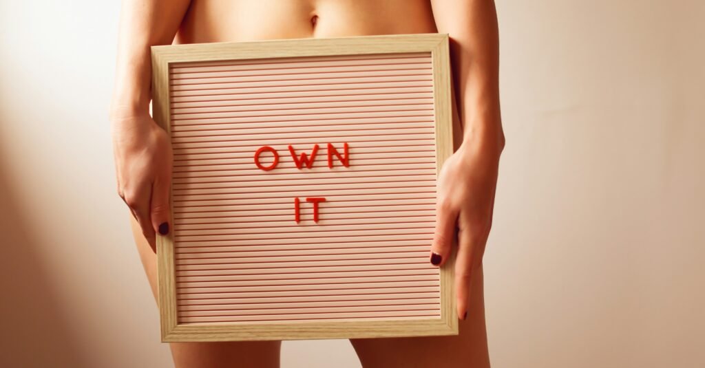 Dieta bezglutenowa, a zdrowie jelit zdjęcie części ciała kobiety trzymającej tablicę z napisem "own it" symbolizującej zdrowie jelit