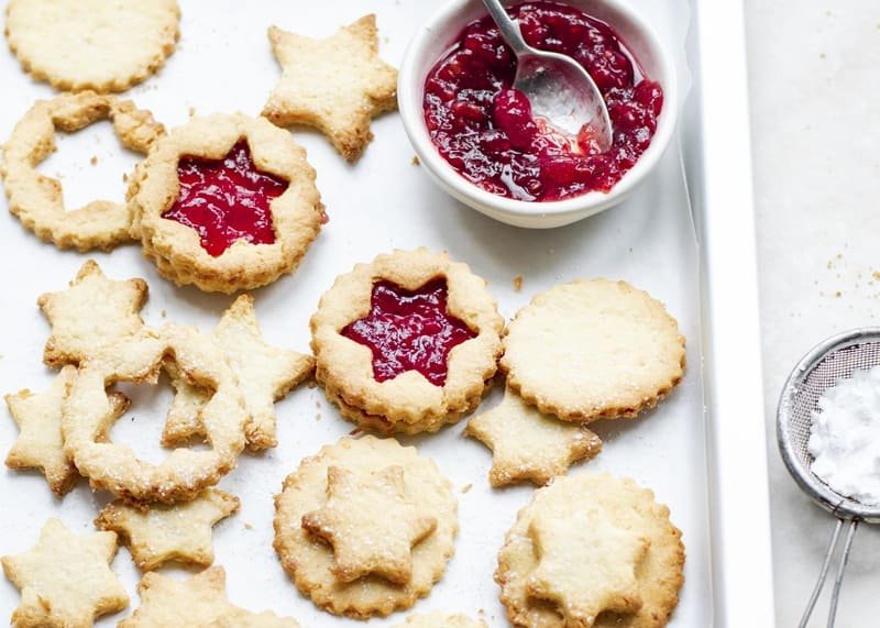 kruche ciasteczka zdjęcie przedstawiające kruche ciasteczka bezglutenowe ułożone na sobie, część jest przełożona konfiturą, a część nie ma dodatków