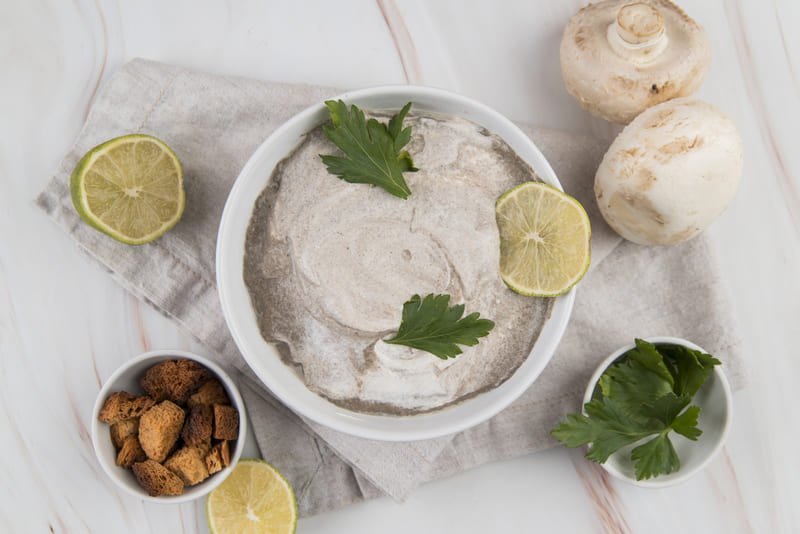 zdjęcie smalcu bez glutenu podanego w białej miseczce, z dodatkiem liści pietruszki i plasterka limonki