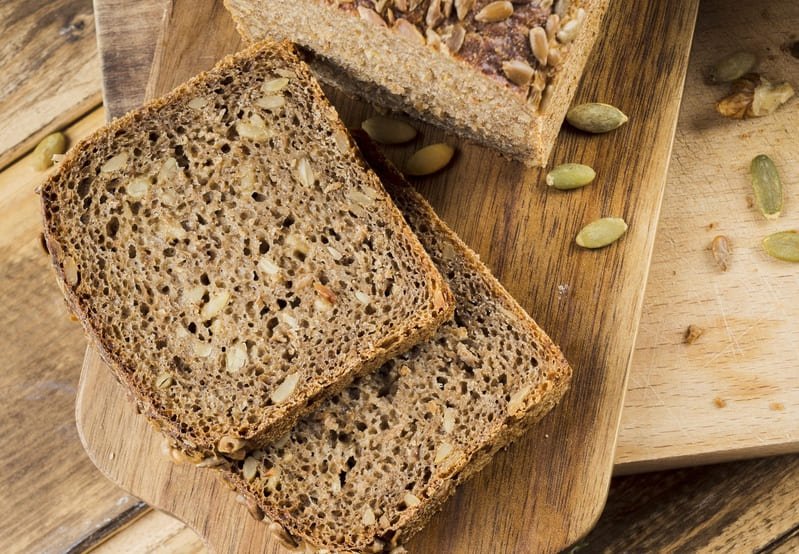 Chleb bez mąki z ziaren na drewnianej desce w domowym otoczeniu