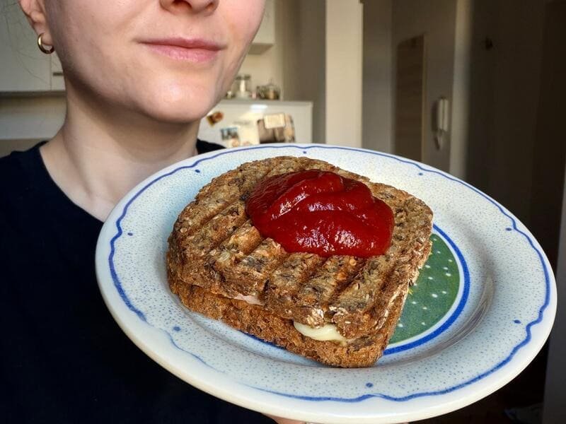 Tost przygotowany z bezglutenowego chleba owsianego Putka z roztopionym serem i ketchupem.