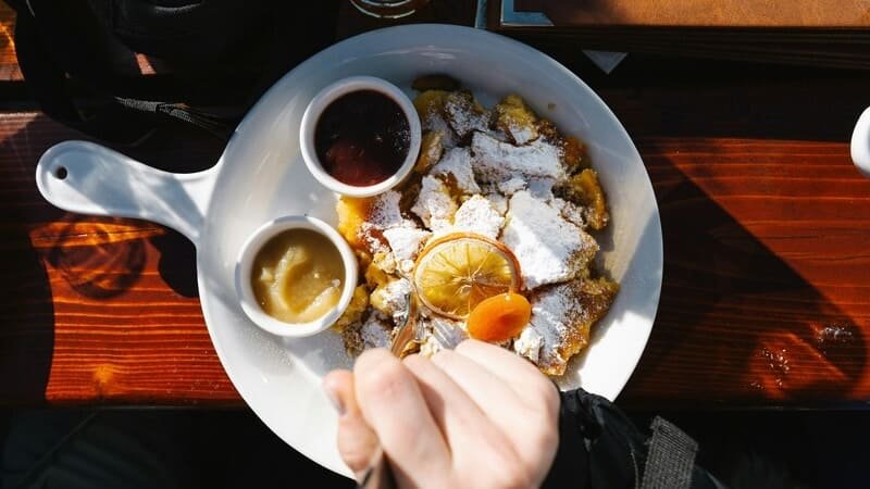 Kaiserschmarrn bez glutenu z cukrem pudrem i owocowymi dodatkami